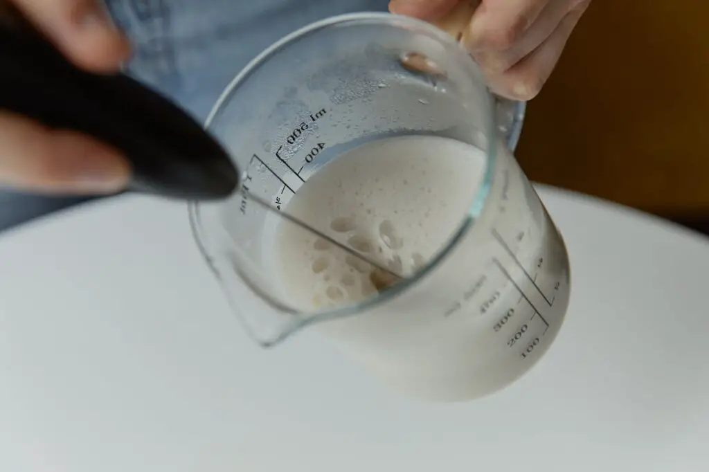 a person holding glass measuring cup